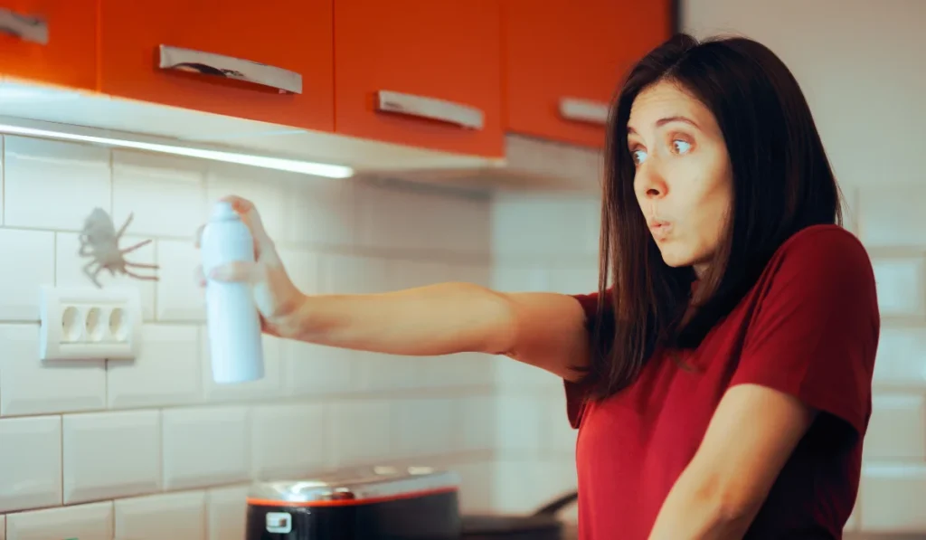 Scared Woman Spraying with Insecticide a Huge Spider Girl suffering from arachnophobia fighting domestic pests